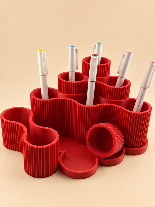 RIPPLE wavy pen holder in scarlet red on a desk